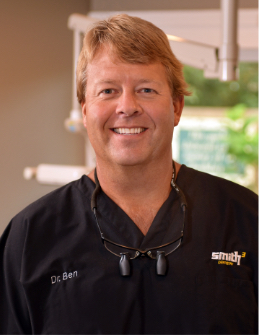 Dr. Clayton B. Smith III, our Wilmington NC dentist, smiling in his dental scrubs 